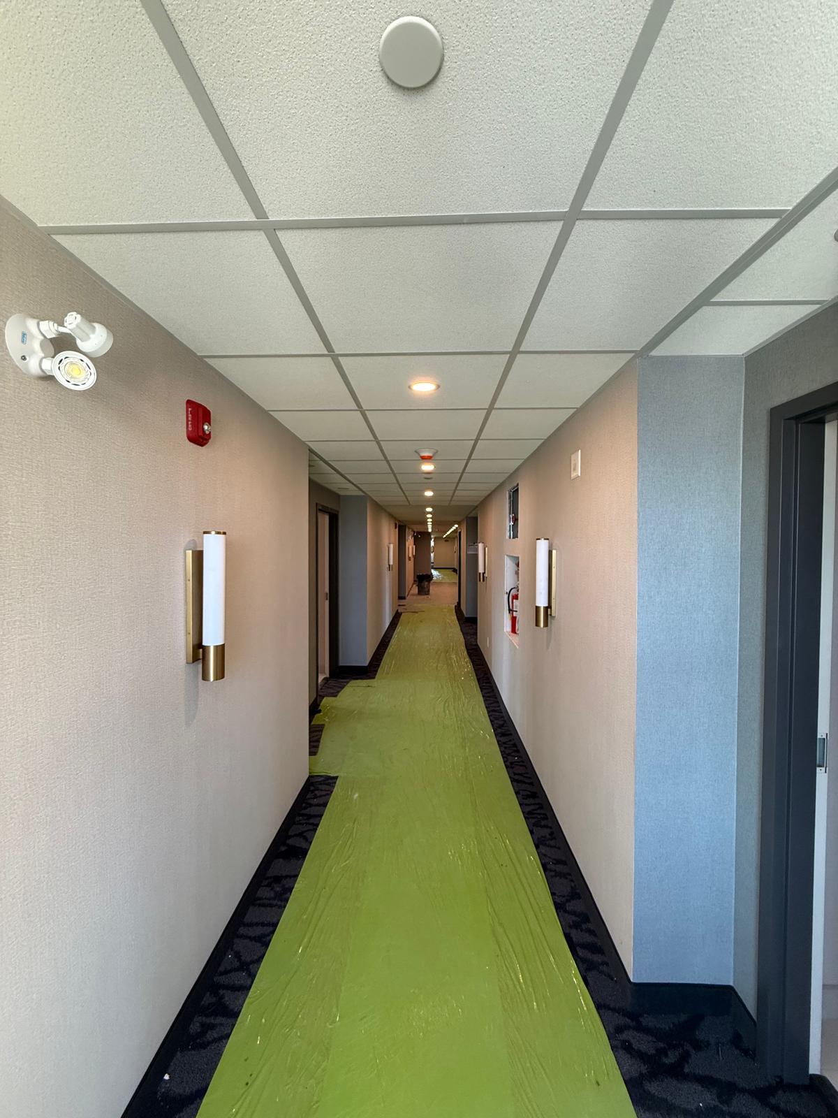 Commercial corridor with suspended acoustic tile ceiling and finished walls