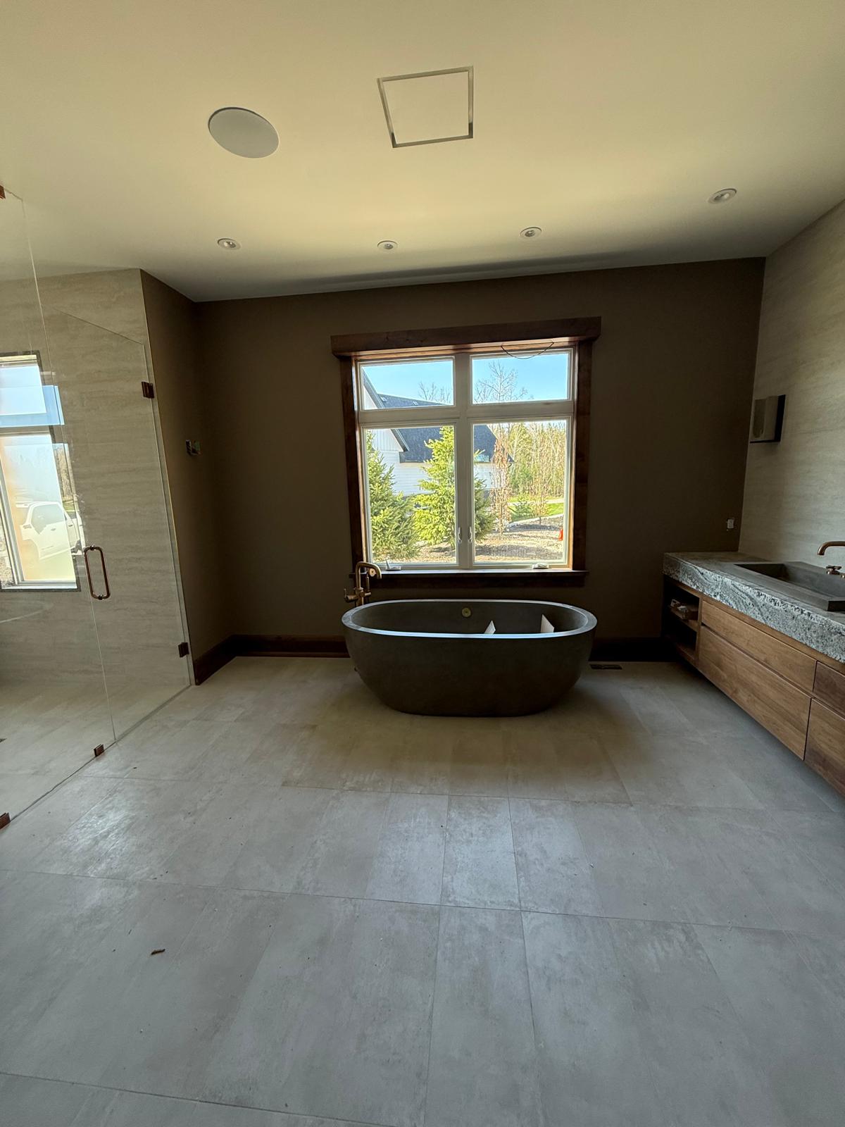 Renovated residential bathroom with freestanding tub, tiled shower and wood vanity
