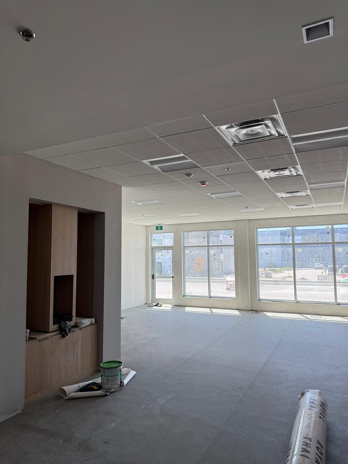 Bright commercial interior with suspended acoustic ceiling, integrated lighting and millwork