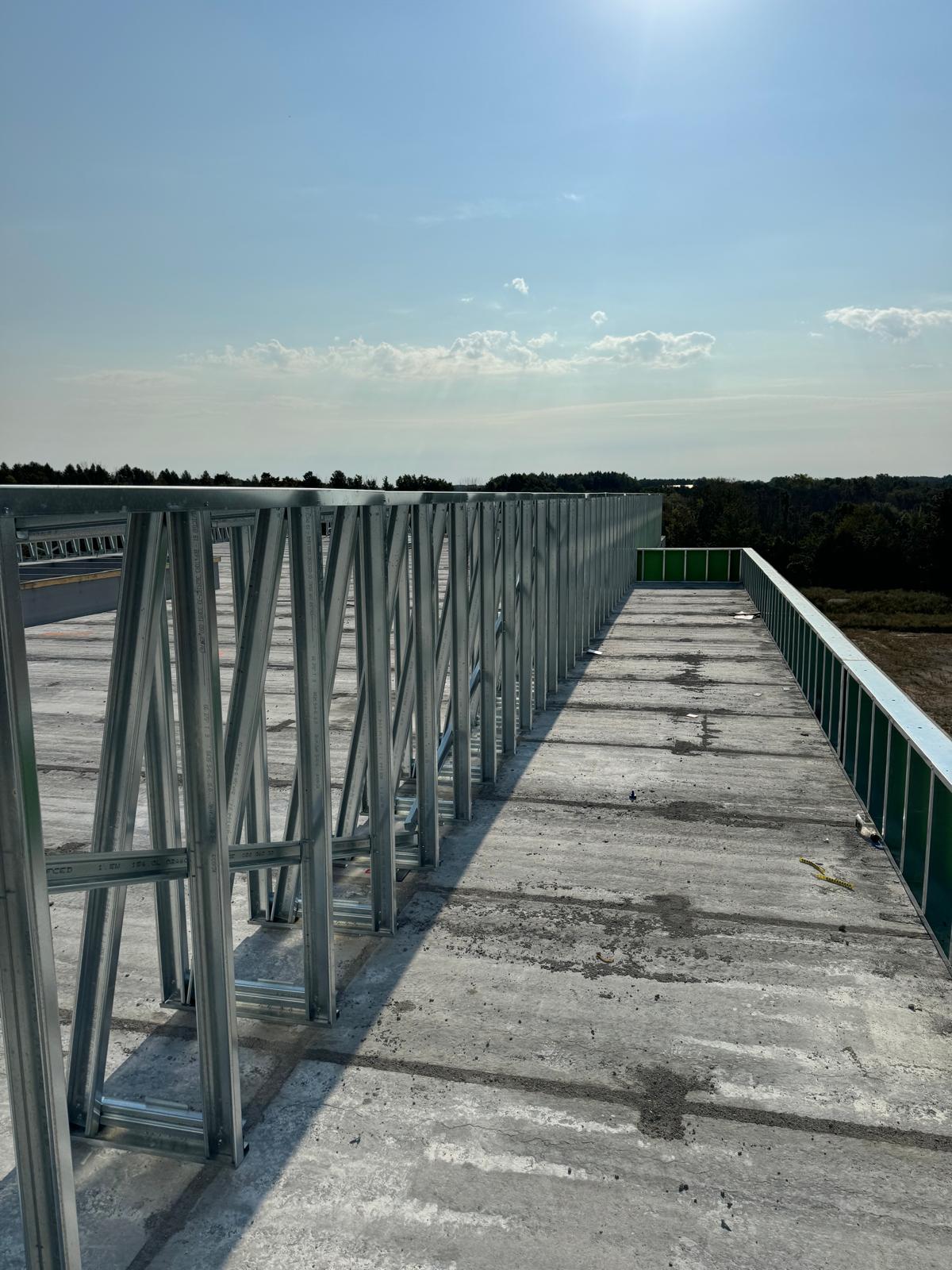 Row of braced steel parapet frames along a rooftop edge