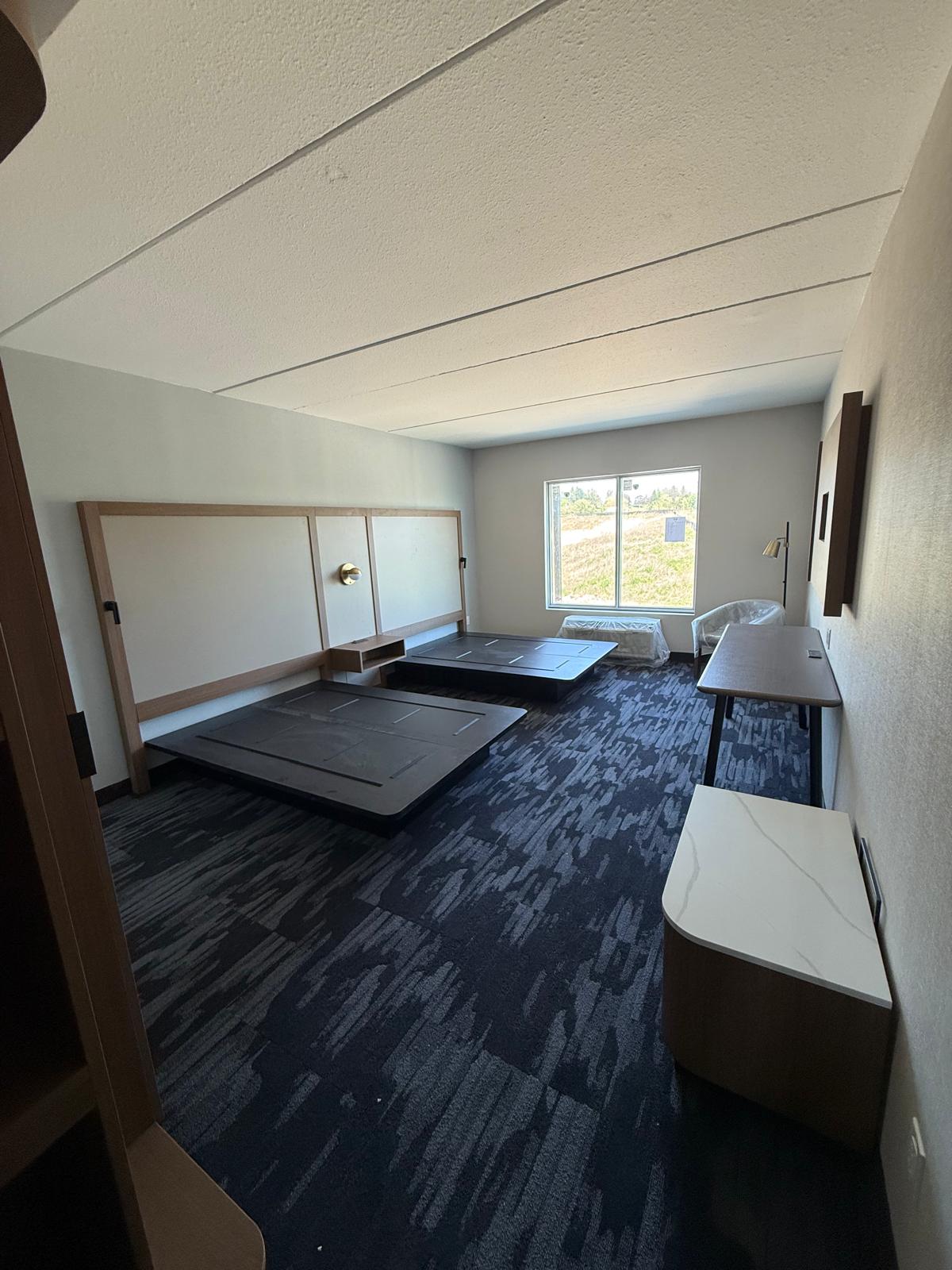 Finished guest room with acoustic ceiling, wall panels, flooring and built-in furnishings