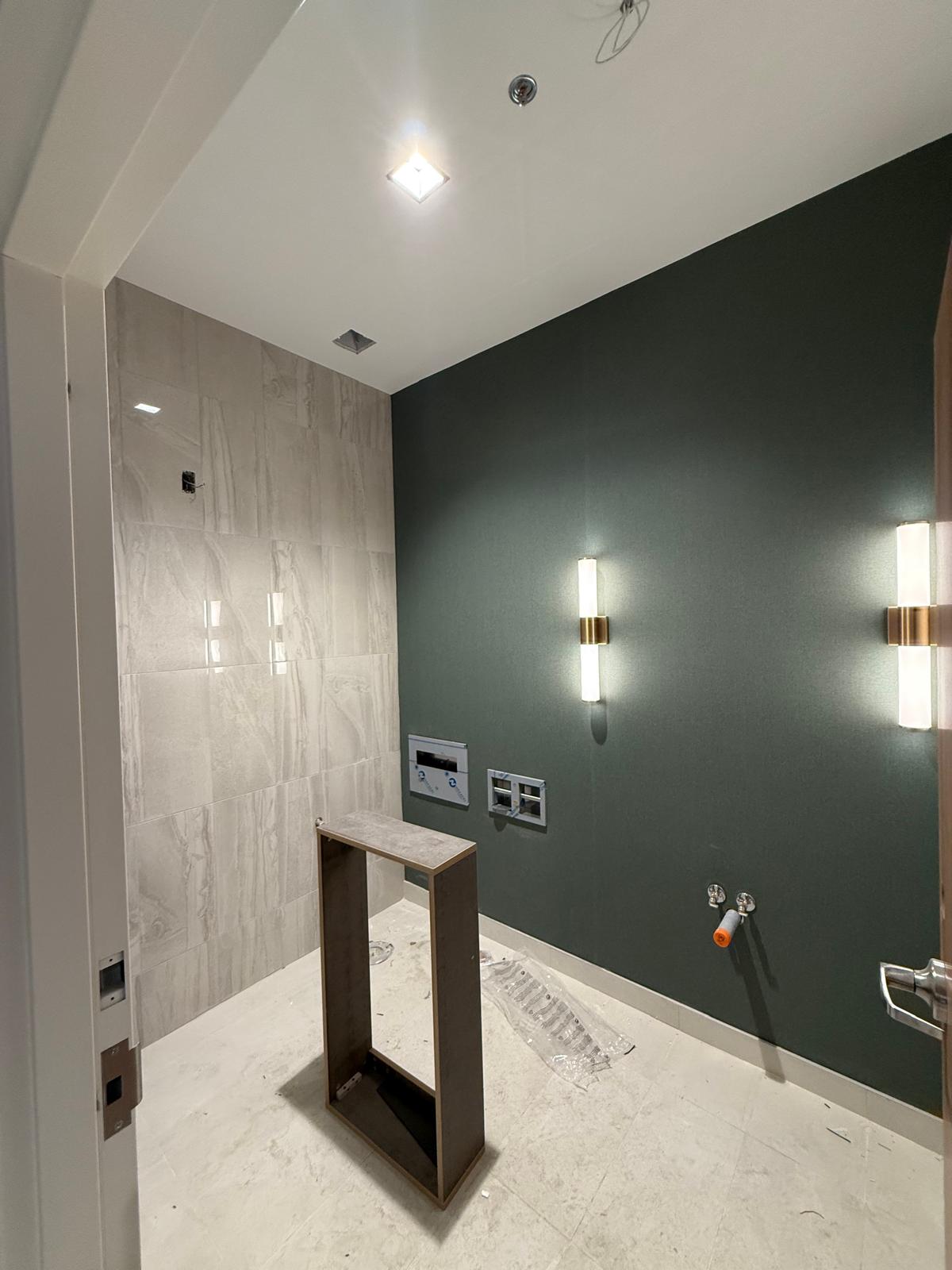 Washroom renovation with tiled feature wall, painted accent wall and modern sconces