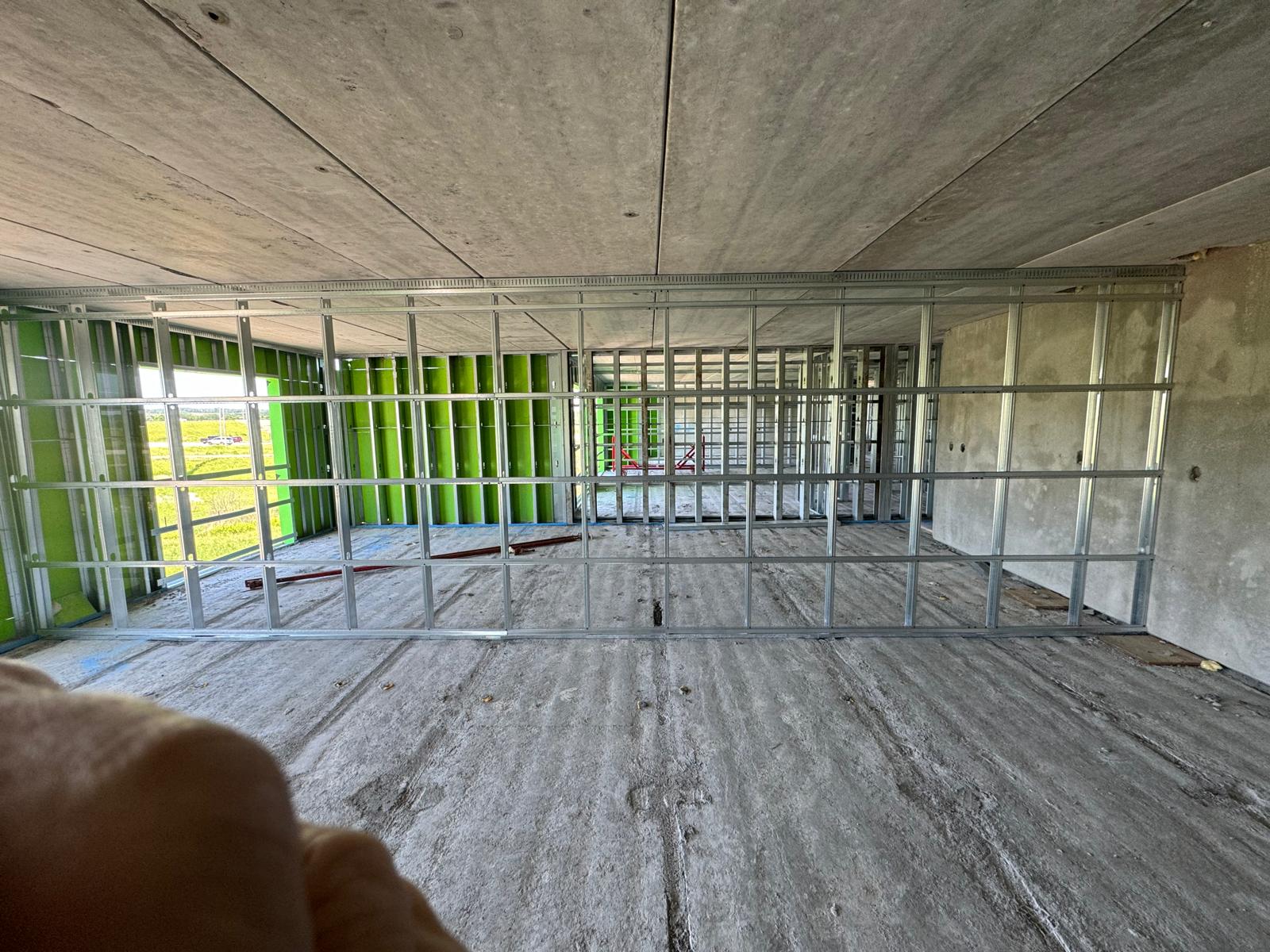 Full-height light-gauge steel partition framing inside a concrete commercial structure
