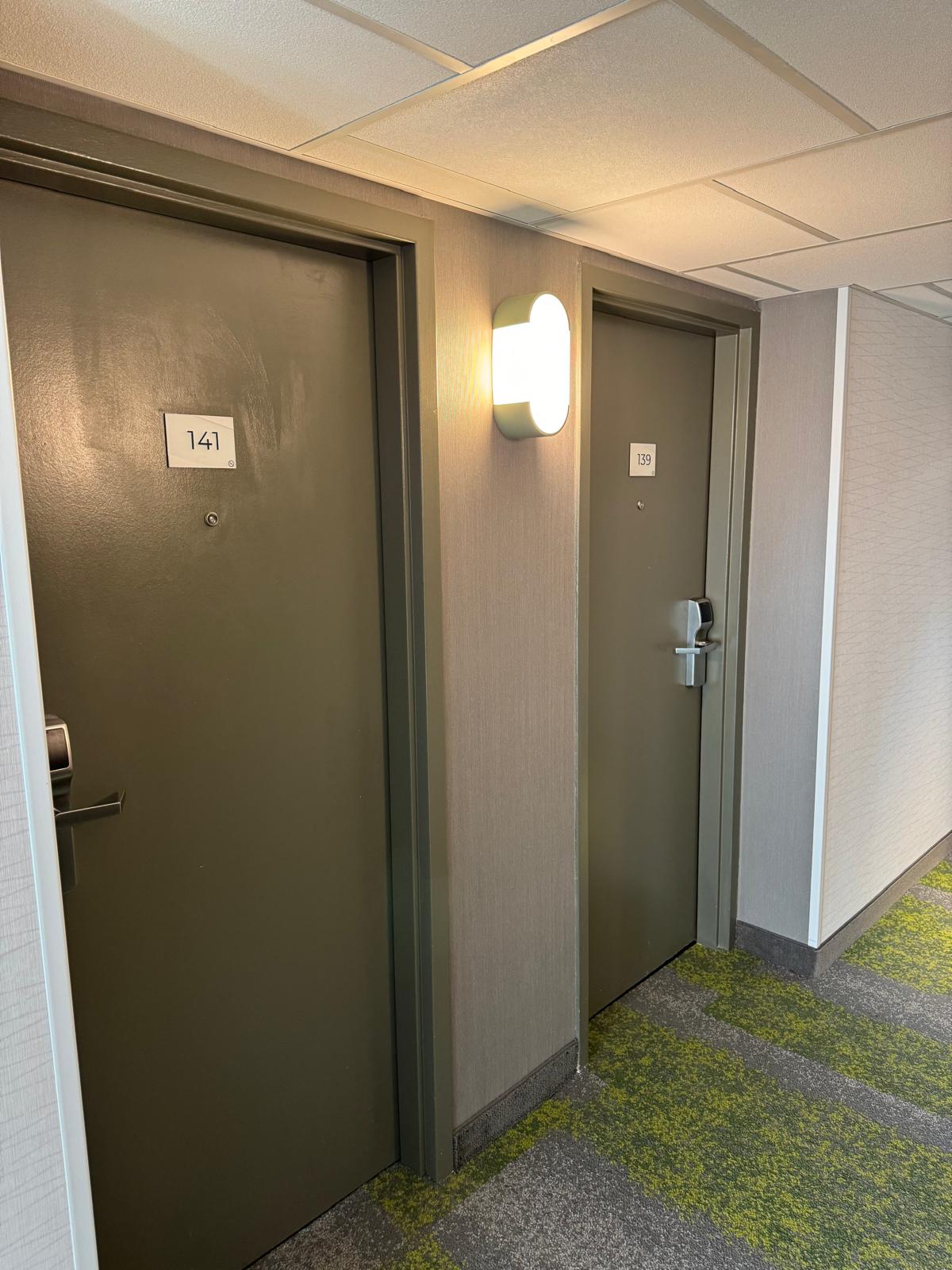 Completed hospitality corridor with acoustic ceiling, finished doors and wall coverings